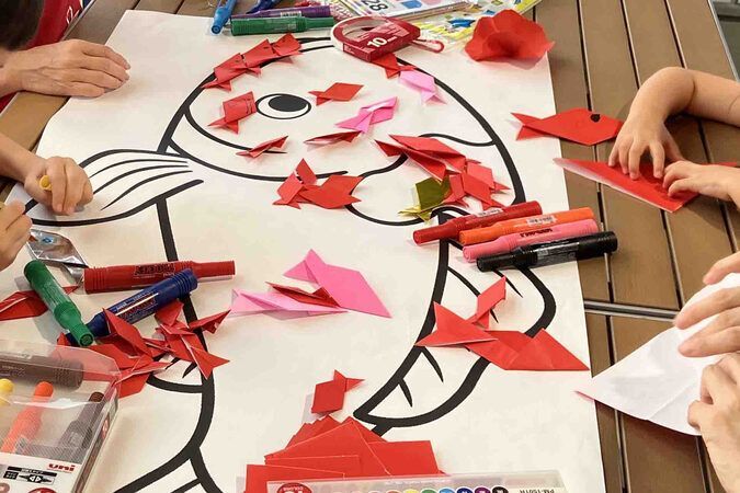 ちからをあわせて折り紙スイミー/折り紙の小さな魚を台紙にペタペタ貼って、大きな魚のアートを作る協力型ワークショップ