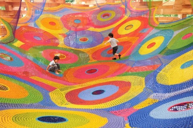 大断面集成材を積み上げた木造ドームの中に、カラフルな手編みのネットがいくつもつなぎ合わされた巨大なハンモック「ネットの森」