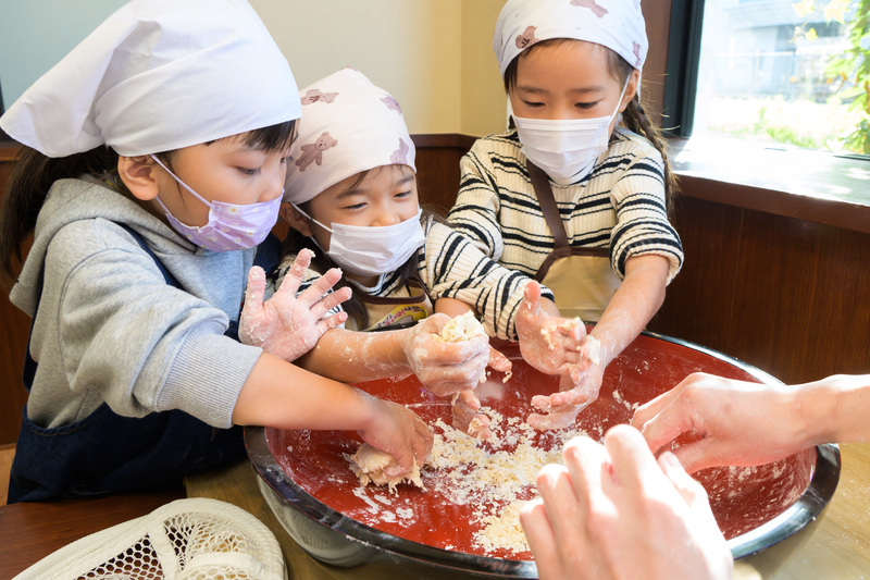手でこねたり、足で踏んだりし、うどんの生地を作ろう!
