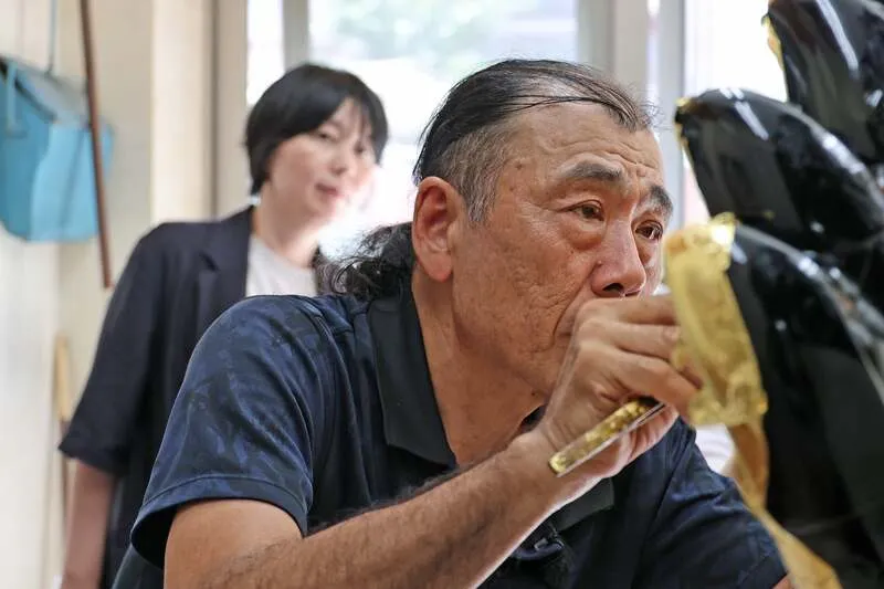細い筆で余分な金箔を取り除きながら丁寧に貼り付けていく