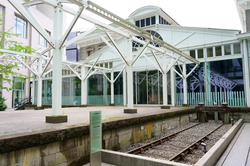 JR新橋駅「銀座口」から徒歩約5分の場所にある「鉄道歴史展示室」には、日本の鉄道の出発点となった0哩標識と復元軌道が設置されています