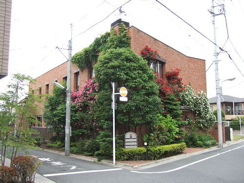 赤レンガ造りの建物と緑の木々が特徴