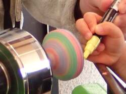 木工旋盤という木材を回転させる機械でコマ絵付け