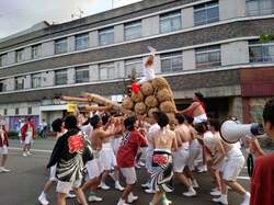「御輿の上で激しい逆立ち対決!? 見たことない迫力満点の夏祭りが片山津温泉で開催」の写真