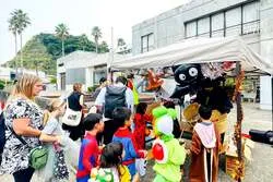 地元の店舗や住民からお菓子を受け取る子供たち