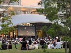 日が沈んだ公園にスクリーンが現れ、坂本龍一さんのピアノが静かに広場へと響きます