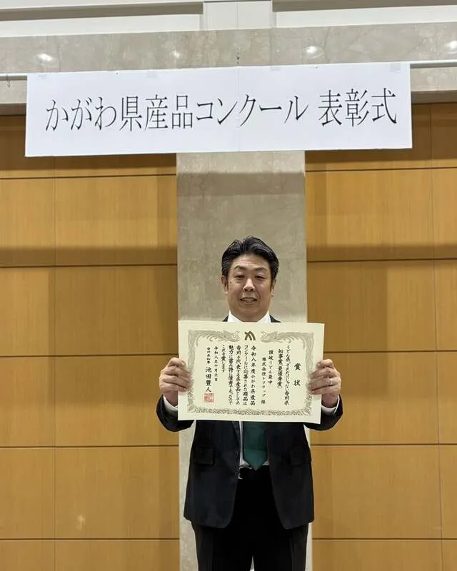 知事賞（最優秀賞）の賞状を手にする代表取締役の新開勝之さん