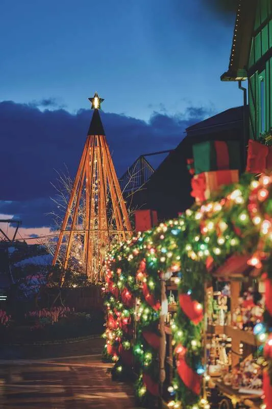 ヒノキと赤いリボンで覆われるマーケットと「クリスマスタワー」の心温まる風景