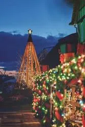 ヒノキと赤いリボンで覆われるマーケットと「クリスマスタワー」の心温まる風景